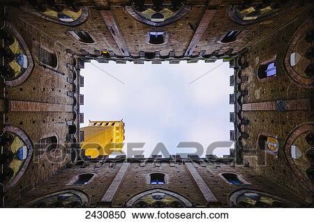 Low angle view to the sky inside the four walls of the Torre del Mangia; Siena, Tuscany, Italy View Large Photo Image Stock Image - Low angle view to the sky inside the four walls of the Torre del Mangia; Siena, Tuscany, Italy. Fotosearch