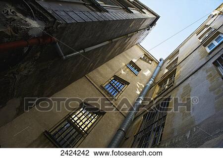 Stock Image - Low angle view up the side of residential buildings in the historical district of Marais; Paris, France. Fotosearch