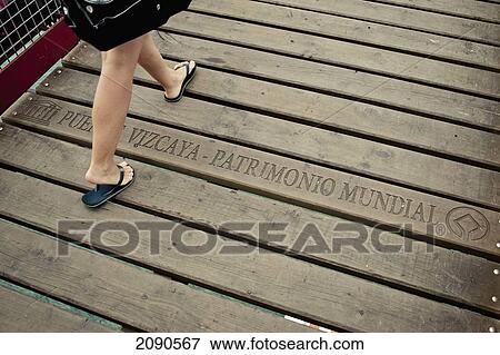 Low Section Of A Woman Walking On Vizcaya Bridge, First Shuttle Bridge, Between Portugalete And Getxo, Basque Country, Spain View Large Photo Image Stock Photo - Low Section Of A Woman Walking On Vizcaya Bridge, First Shuttle Bridge, Between Portugalete And Getxo, Basque Country, Spain. Fotosearch
