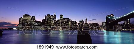 Stock Photo - Lower Manhattan And Brooklyn Bridge Illuminated At Dusk. Fotosearch