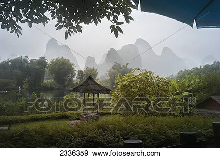 Stock Photo - Lush Foliage And Mountain Peaks On A Rainy Day; Yangshuo, China. Fotosearch