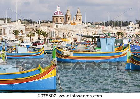 Luzzus, Traditional Maltese Fishing Boats In The Harbour, Marsaxlokk, Malta View Large Photo Image Stock Photo - Luzzus, Traditional Maltese Fishing Boats In The Harbour, Marsaxlokk, Malta. Fotosearch