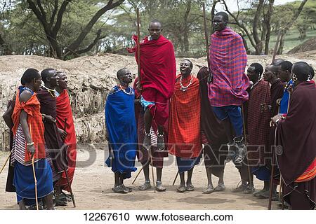 Stock Image - Maasai warriors jump during traditional dance at their village in Ngorongoro Crater Conservation Area; Tanzania. Fotosearch