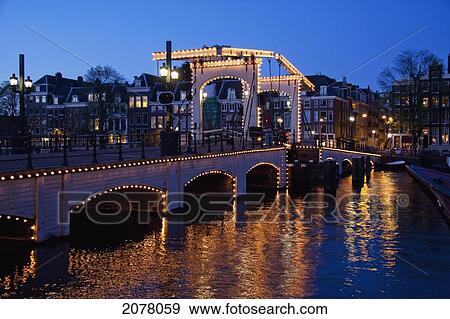 Stock Photo - Magere Brug Over The Amstel River At Night, Amsterdam, Netherlands. Fotosearch