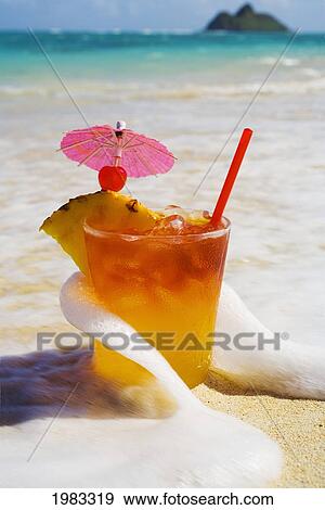 Stock Photo - Mai Tai Getting Splashed By A Wave As It Rest On The Beach.. Fotosearch