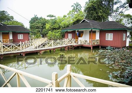 Stock Image - Malaysia, Chalets over lakeside at Firefly Park resort; Selangor. Fotosearch
