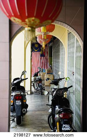 Stock Photo - Malaysia, Pulau Pinang (Penang), Archway over long corridor with scooters parked along side; Georgetown. Fotosearch