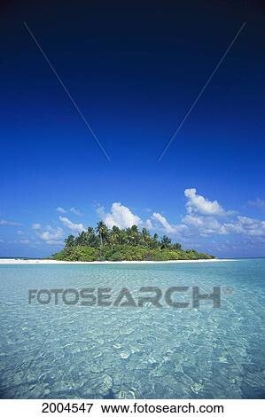 Stock Photo - Maldives, Tropical Island In Distance, Shallow Turquoise Ocean Blue Sky And Clouds. Fotosearch