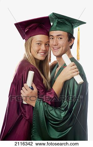 Male and female graduates in cap and gown, holding diplomas. View Large Photo Image Stock Image - Male and female graduates in cap and gown, holding diplomas.. Fotosearch