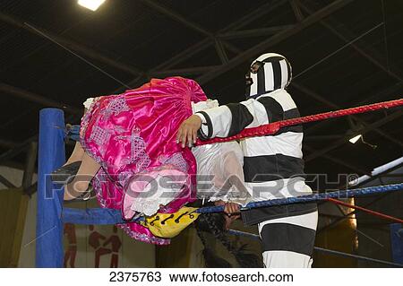 Stock Image - Male and female wrestlers in combat at the Cholitas Wrestling Event, El Alto, La Paz, Bolivia. Fotosearch