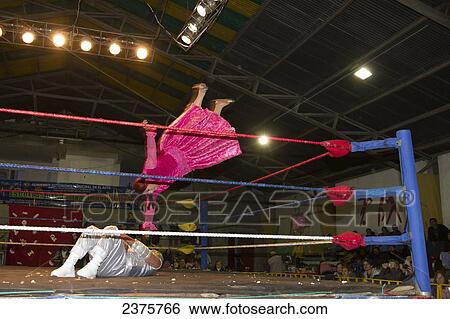 Stock Photograph - Male and female wrestlers in combat at the Cholitas Wrestling Event, El Alto, La Paz, Bolivia. Fotosearch