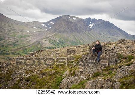Stock Image - Male hiker along Flat Top Mountain trail near Anchorage, Chugach Mountains, Southcentral Alaska, Summer. Fotosearch