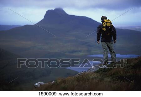 Stock Photo - Male Hiker Standing On The Edge Of Mountain. Fotosearch