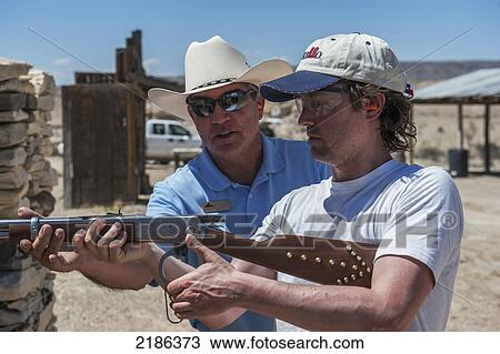 Male Instructor Guides Man About How To Fire Shotgun At Lajitas Resort, Big Bend National Park And Big Bend State Park, South West Texas, Usa View Large Photo Image Stock Image - Male Instructor Guides Man About How To Fire Shotgun At Lajitas Resort, Big Bend National Park And Big Bend State Park, South West Texas, Usa. Fotosearch
