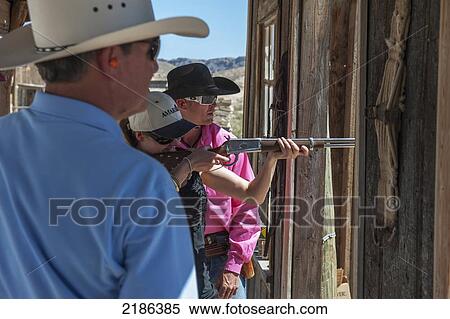 Male Instructor Guides Young Woman About How To Fire Shotgun At Lajitas Resort, Big Bend National Park And Big Bend State Park, South West Texas, Usa View Large Photo Image Stock Photography - Male Instructor Guides Young Woman About How To Fire Shotgun At Lajitas Resort, Big Bend National Park And Big Bend State Park, South West Texas, Usa. Fotosearch