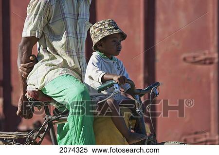 Man And Boy On A Bicycle In Mahavatse, Toliara Province, Madagascar View Large Photo Image Stock Photography - Man And Boy On A Bicycle In Mahavatse, Toliara Province, Madagascar. Fotosearch
