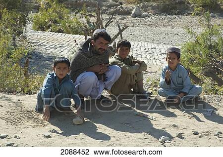 Stock Image - Man And Boys In The Khyber Pass, Federally Administered Tribal Areas, Pakistan. Fotosearch