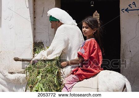 Stock Image - Man And Girl On A Donkey, Dendara, Qina, Egypt. Fotosearch