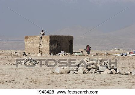 Stock Photo - Man And Woman By A Brick House In The Outskirts Of Kabul,, Afghanistan. Fotosearch