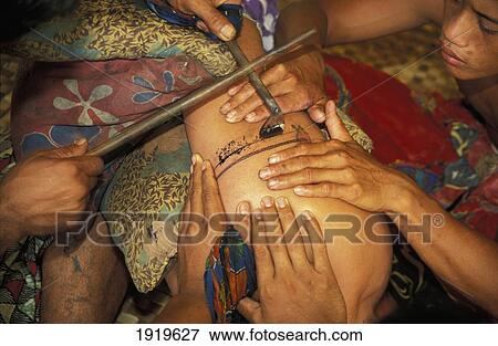 Stock Photo - Man Being Tatooed By Traditional Method. Fotosearch