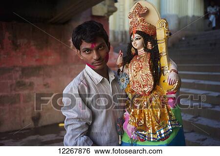 Stock Photograph - Man bringing an idol to Saraswati Puja at Babu Ghat; Kolkata, West Bengal, India. Fotosearch
