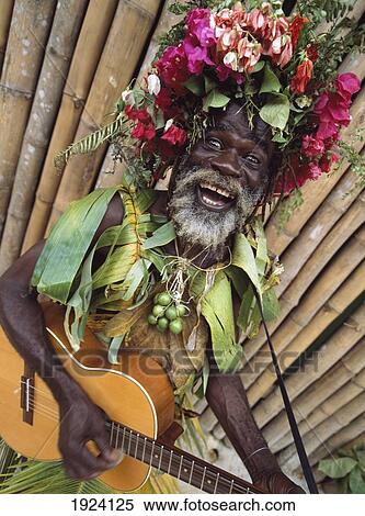 Stock Photography - Man Busking For Money In Island Village. Fotosearch