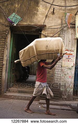 Man carrying sack on his head; Kolkata, West Bengal, India View Large Photo Image Picture - Man carrying sack on his head; Kolkata, West Bengal, India. Fotosearch