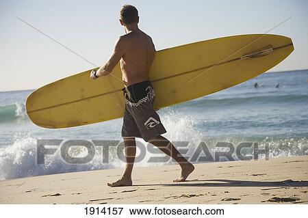 Stock Photo - Man Carrying Surfboard On Bondi Beach. Fotosearch