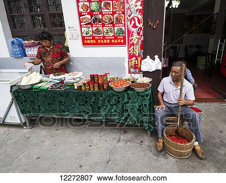 Man crushing hot peppers, Hongcun, Anhui, China View Large Photo Image Stock Photo - Man crushing hot peppers, Hongcun, Anhui, China. Fotosearch