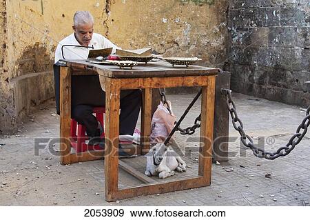 Man Cutting Metal Dishes With A Goat Keeping Him Company, Cairo, Al Qahirah, Egypt View Large Photo Image Stock Photo - Man Cutting Metal Dishes With A Goat Keeping Him Company, Cairo, Al Qahirah, Egypt. Fotosearch