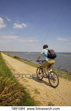 Man Cycling Along Seawall From Lymington View Large Photo Image Picture - Man Cycling Along Seawall From Lymington. Fotosearch