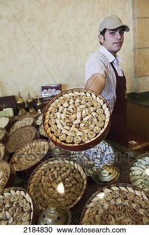 Stock Image - Man Displaying Traditional Arabic Sweets, Mediterranean Sweets Or Middle Eastern Sweets Made At The Zalatimo Sweetshop, Amman, Jordan, Middle East. Fotosearch
