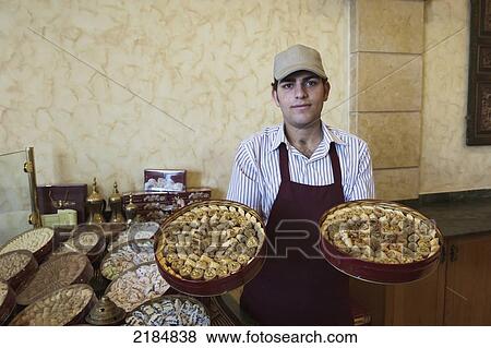 Stock Photo - Man Displaying Traditional Arabic Sweets, Mediterranean Sweets Or Middle Eastern Sweets Made At The Zalatimo Sweetshop, Amman, Jordan, Middle East. Fotosearch