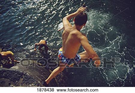 Stock Photo - Man Diving Off Of Cliff Into The Ocean. Fotosearch