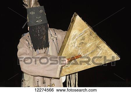 Stock Photograph - Man dressed as a Mongolian shaman at the Ongiin Nuts Ger Camp at night, Saikhan-Ovoo, Dundgovi Province, Mongolia. Fotosearch