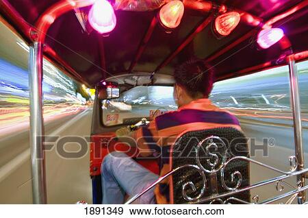 Stock Photo - Man Driving Tuk-Tuk At Night. Fotosearch