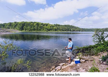 Stock Photo - Man fishing at pond in Hilton Falls Conservation Area; Campbellville, Ontario, Canda. Fotosearch