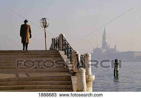 Stock Image - Man Going Up Stairs On The Side Of The Lagoon. Fotosearch