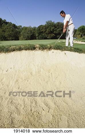 Stock Photo - Man Golfing Near Sand Dune. Fotosearch