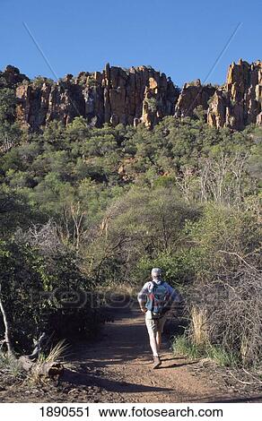 Stock Image - Man Hiking Towards Plateau, Rear View. Fotosearch
