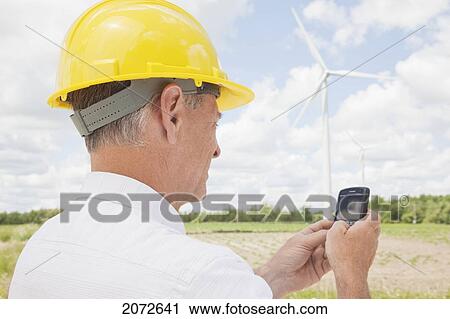 Man In Hard Hat Texting On Wind Farm, Near Shelburne, Ontario View Large Photo Image Stock Image - Man In Hard Hat Texting On Wind Farm, Near Shelburne, Ontario. Fotosearch