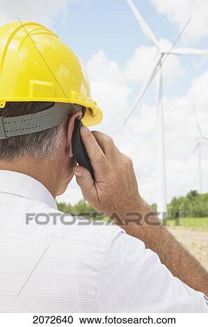 Man In Hard Hat Using Cellphone On Wind Farm, Near Shelburne, Ontario View Large Photo Image Stock Image - Man In Hard Hat Using Cellphone On Wind Farm, Near Shelburne, Ontario. Fotosearch