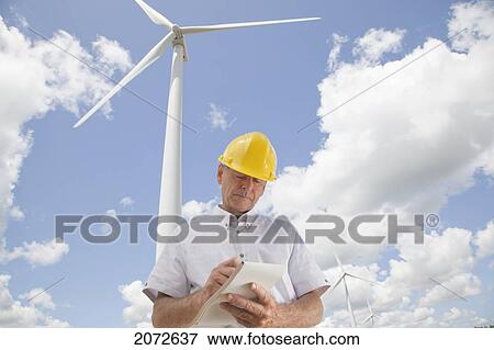 Man In Hard Hat Writing In Notebook On Wind Farm, Near Shelburne, Ontario View Large Photo Image Stock Photo - Man In Hard Hat Writing In Notebook On Wind Farm, Near Shelburne, Ontario. Fotosearch