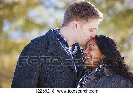 Man in his 20Æs kissing his fiance on the forehead in Scanlon Creek Conservation Area; Ontario, Canada View Large Photo Image Stock Photo - Man in his 20Æs kissing his fiance on the forehead in Scanlon Creek Conservation Area; Ontario, Canada. Fotosearch