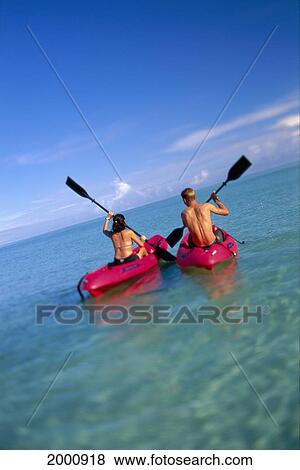 Stock Photo - Man In Kayak Woman At Side With Arms Around Each Other Smiling, Calm Ocean. Fotosearch