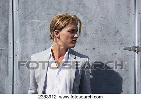 Stock Image - Man in suit jacket with his hair pulled back; Langley, British Columbia, Canada. Fotosearch