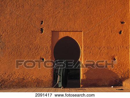 Stock Photo - Man In Traditional Djelleba Walking Through Small Doorway In The City Walls Of Marrakesh, Morocco.. Fotosearch