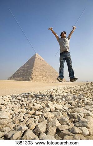 Man Jumping In Air With Pyramid In Background View Large Photo Image Stock Image - Man Jumping In Air With Pyramid In Background. Fotosearch