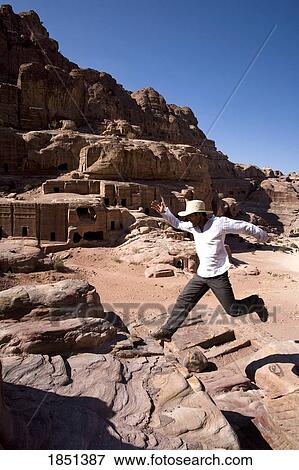 Stock Photo - Man Jumping Near Monumental Nabataean Tombs. Fotosearch