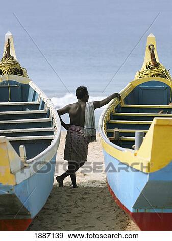 Man Leaning On Fishing Boats On Beach View Large Photo Image Stock Photo - Man Leaning On Fishing Boats On Beach. Fotosearch